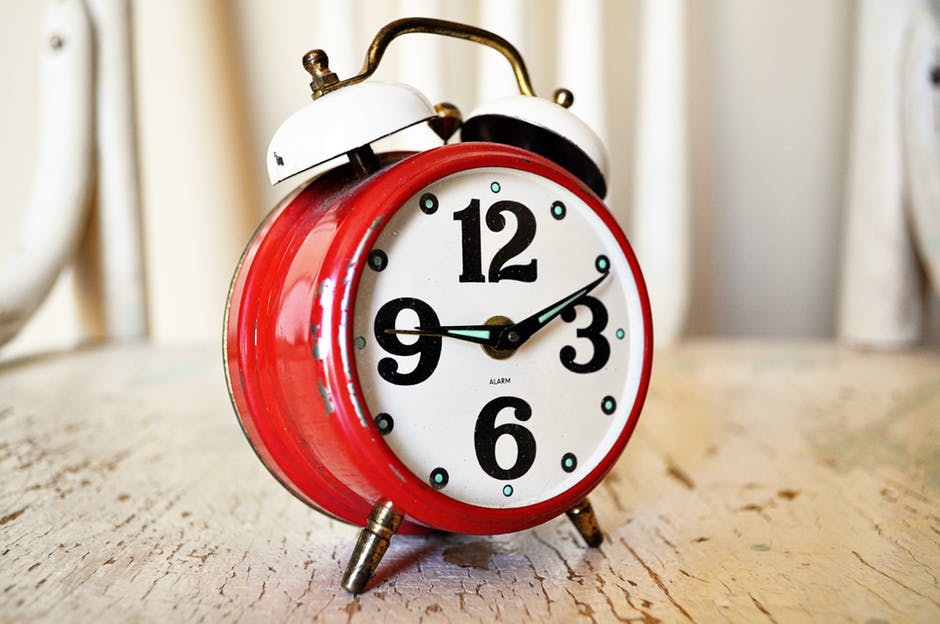 red old-fashioned alarm clock on table